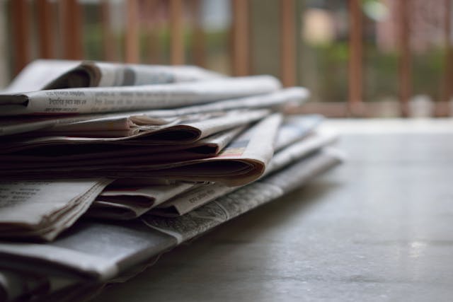 a pile of newspapers on a porch