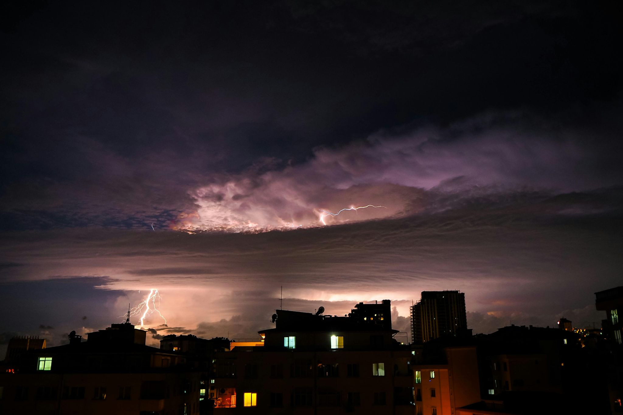 Thunderclouds, lightning and rain above the city