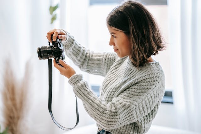 A person taking a photo with a black camera