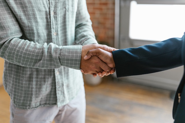 two people shaking hands in an empty room