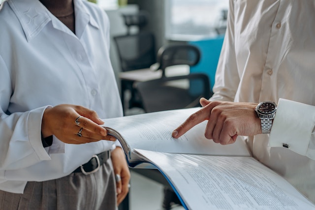 two people standing and going over a document together